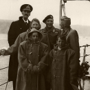 Kongefamilien på dekk. HMS Norfolk har ankommet Oslofjorden. Været var kaldt - barna fikk låne varme klær av mannskapet. Foto: the Royal Navy